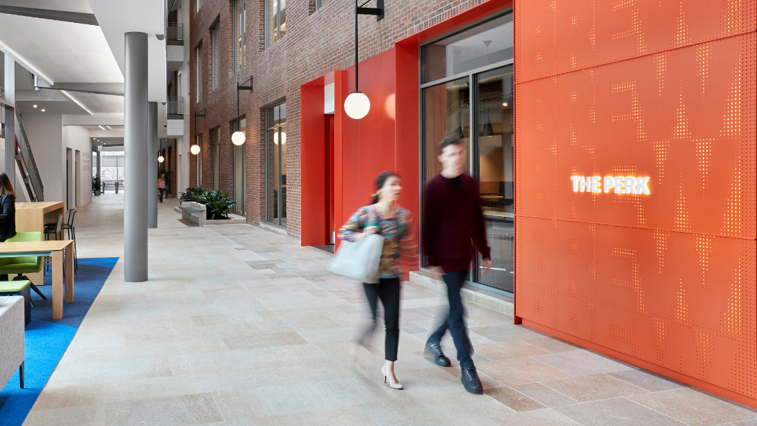 A couple of women walking down a sidewalk.