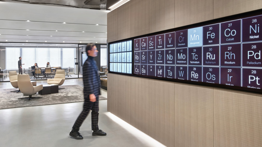 A person standing in a room with a large screen.