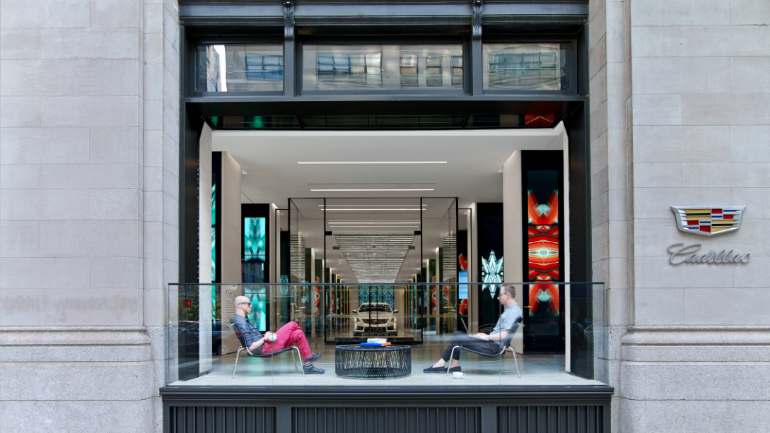 A group of people sitting on a bench outside a building.