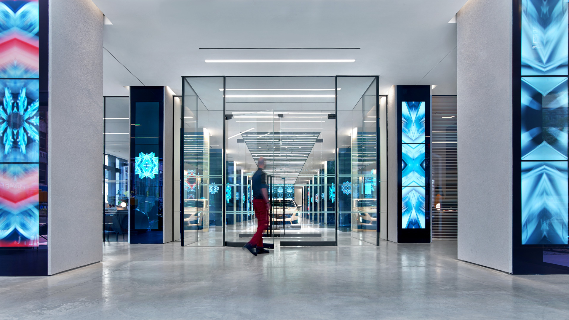 A person standing in a large room with glass doors.