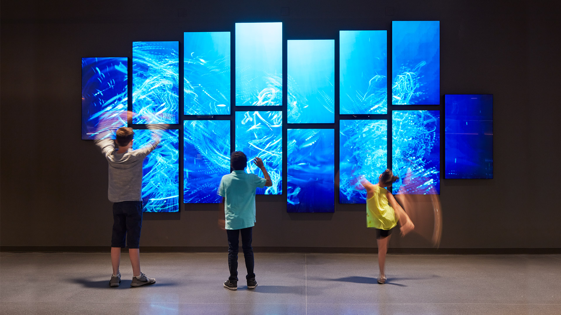 A group of people looking at a large screen.