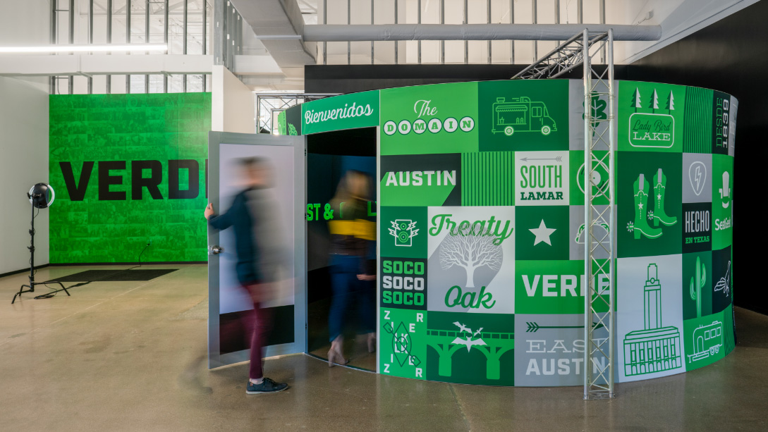 A group of people standing next to a green box.