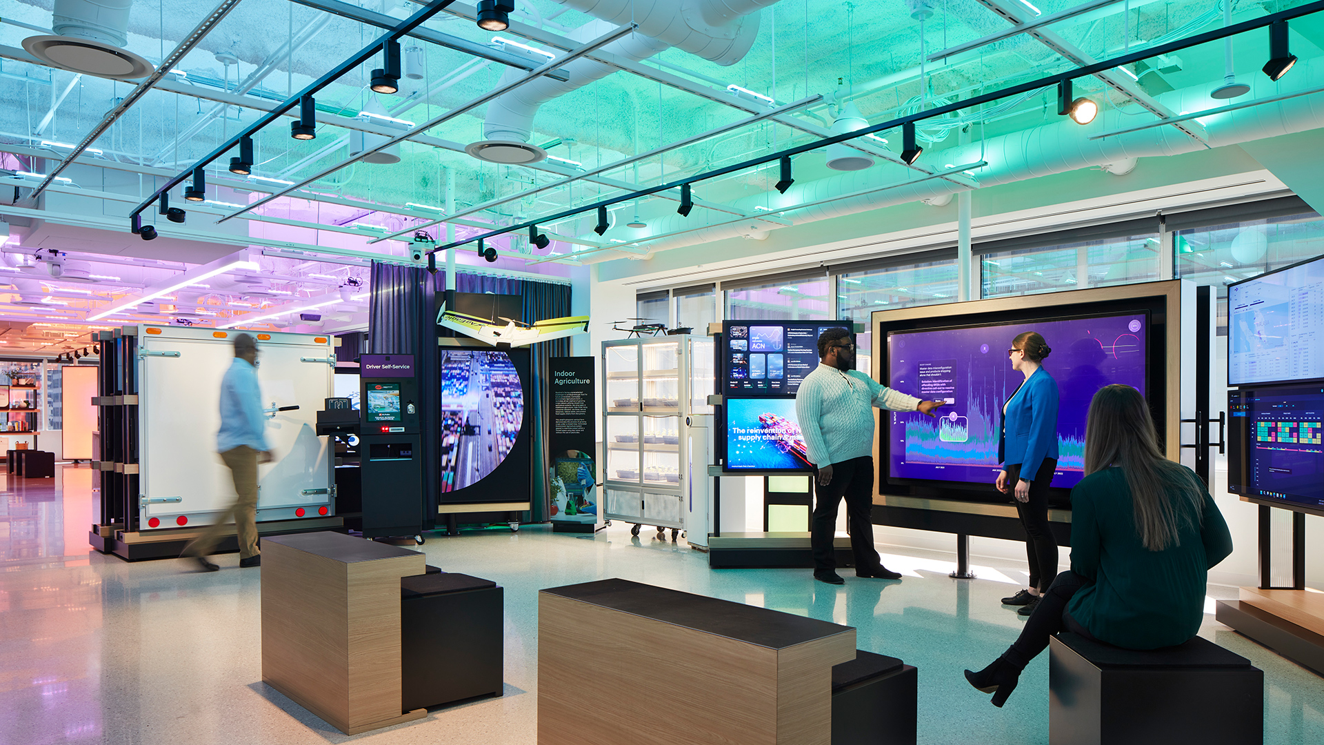People in a room with large screens.