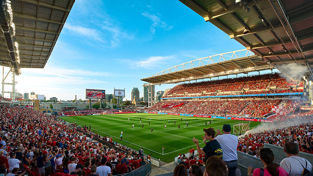 A football stadium with a field and players on the field.