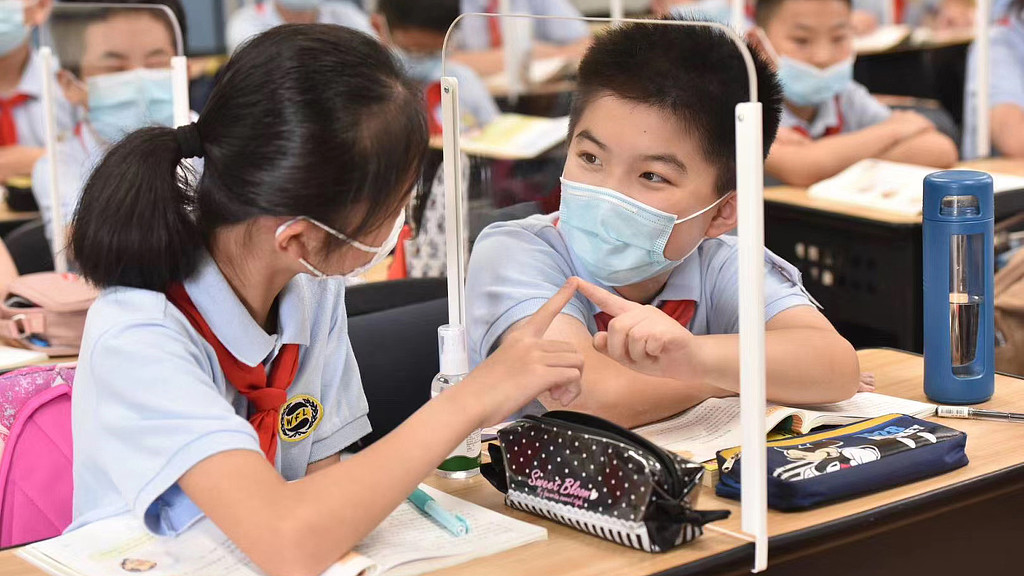 A few young girls in a classroom.