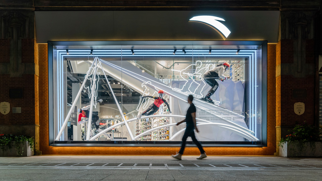 A person walking past a storefront display.