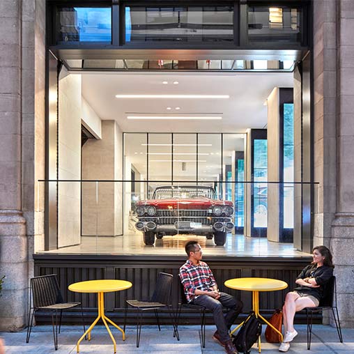 A couple of men sitting at a table in front of a building.