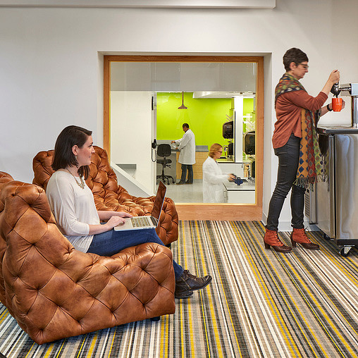 A man and a woman sitting on a couch in a room.