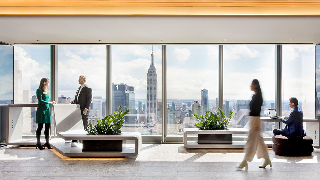 A group of people in a room with large windows.