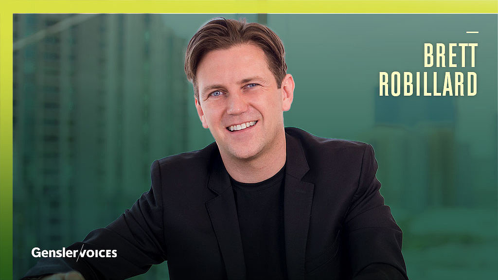 A man smiling in front of a green screen.