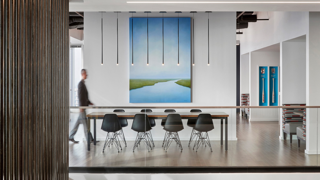 A person standing in front of a large screen in a room.