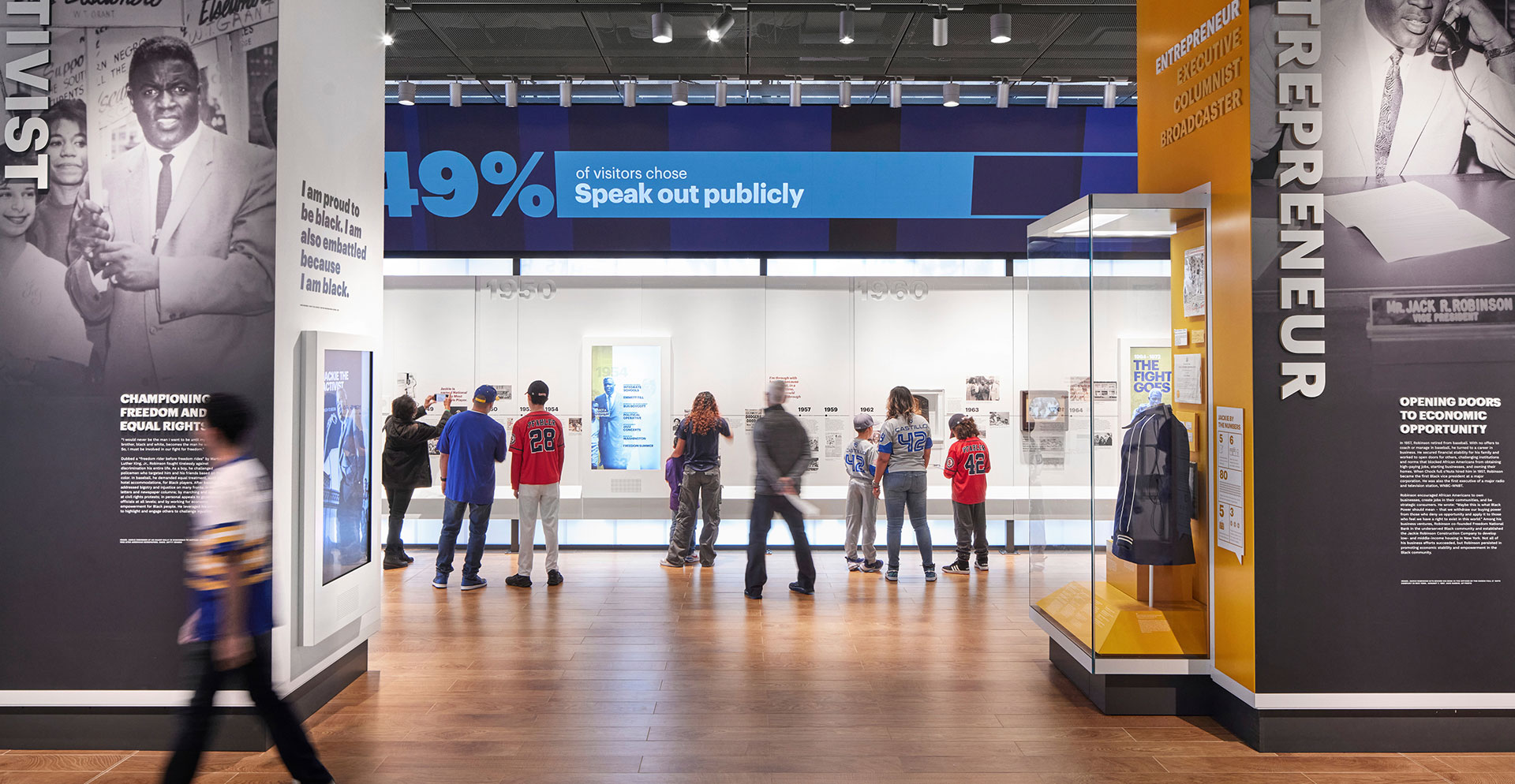 A group of people in a large room with a sign.