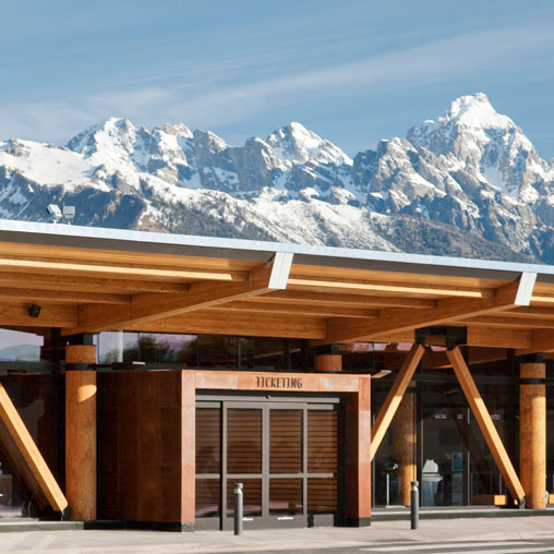 A building with snow covered mountains in the background.