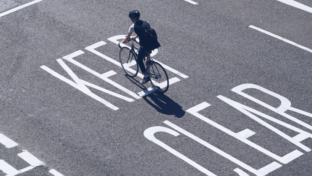 A person riding a bicycle in a parking lot.