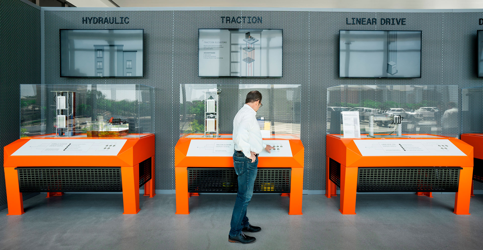 A person standing in front of a table with a screen on it.