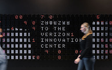 A man standing in front of a computer screen.