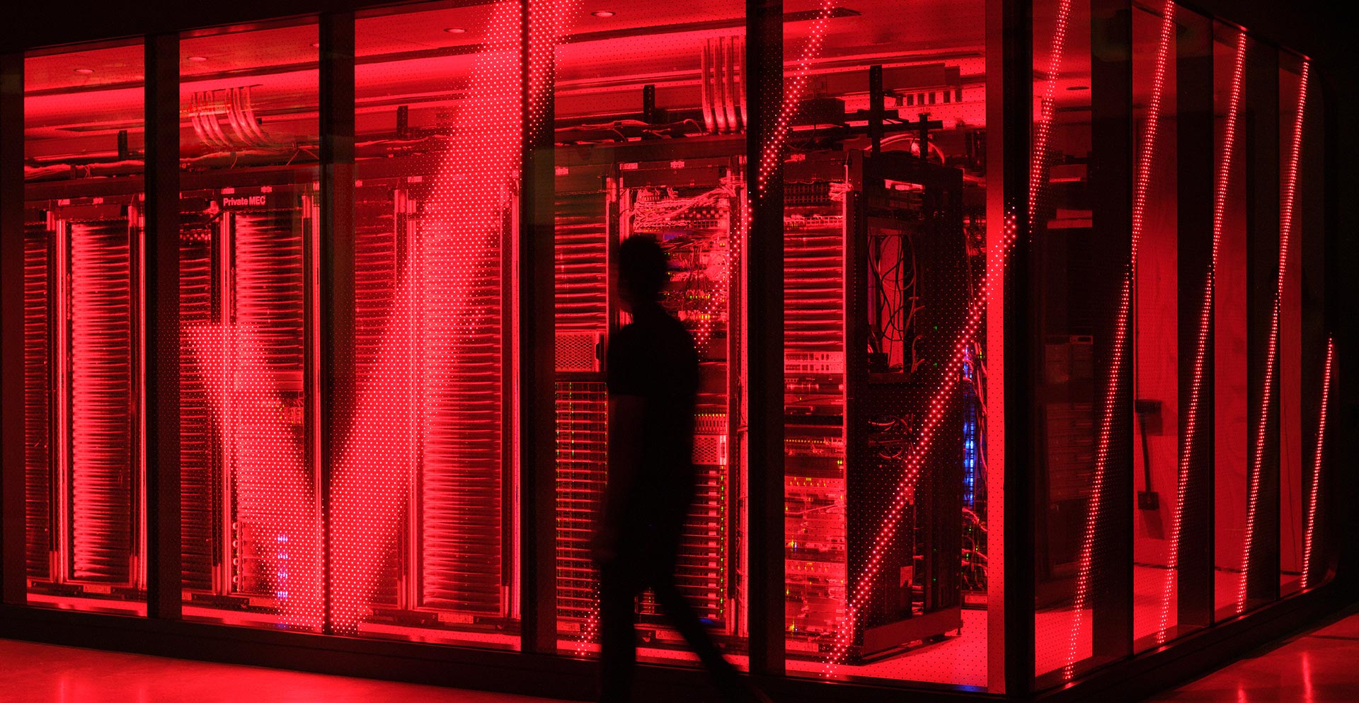 A person standing in a room with red lights.