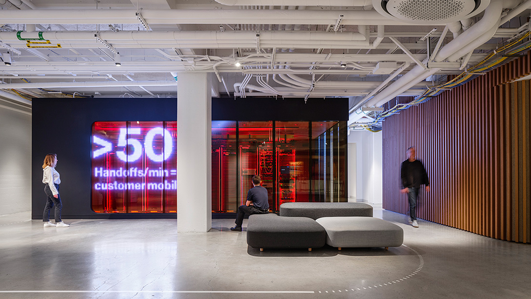A group of people in a room with a large screen.
