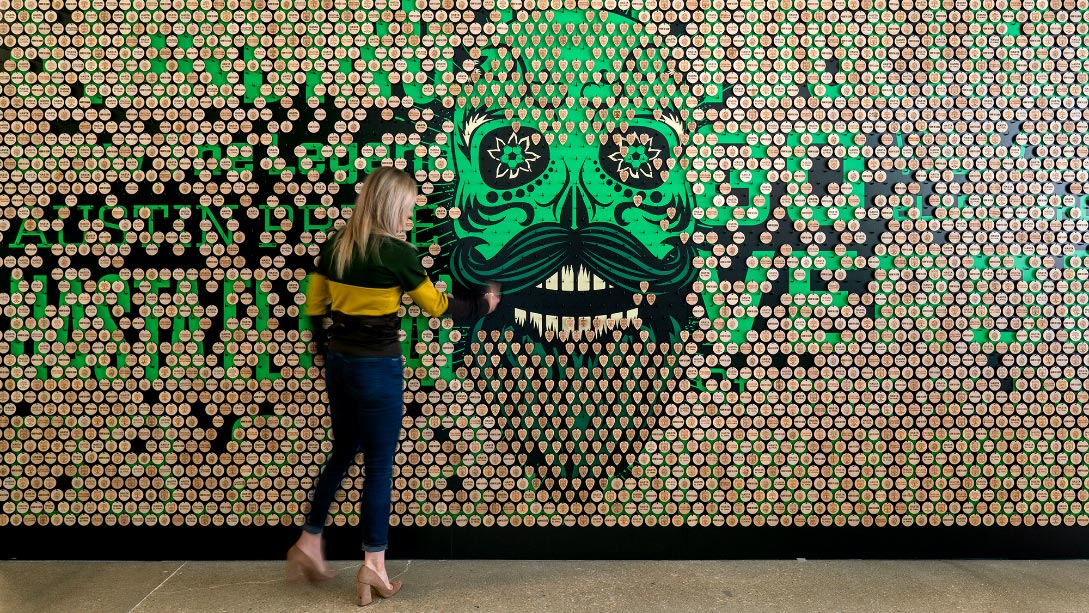A person standing in front of a wall with a cartoon.
