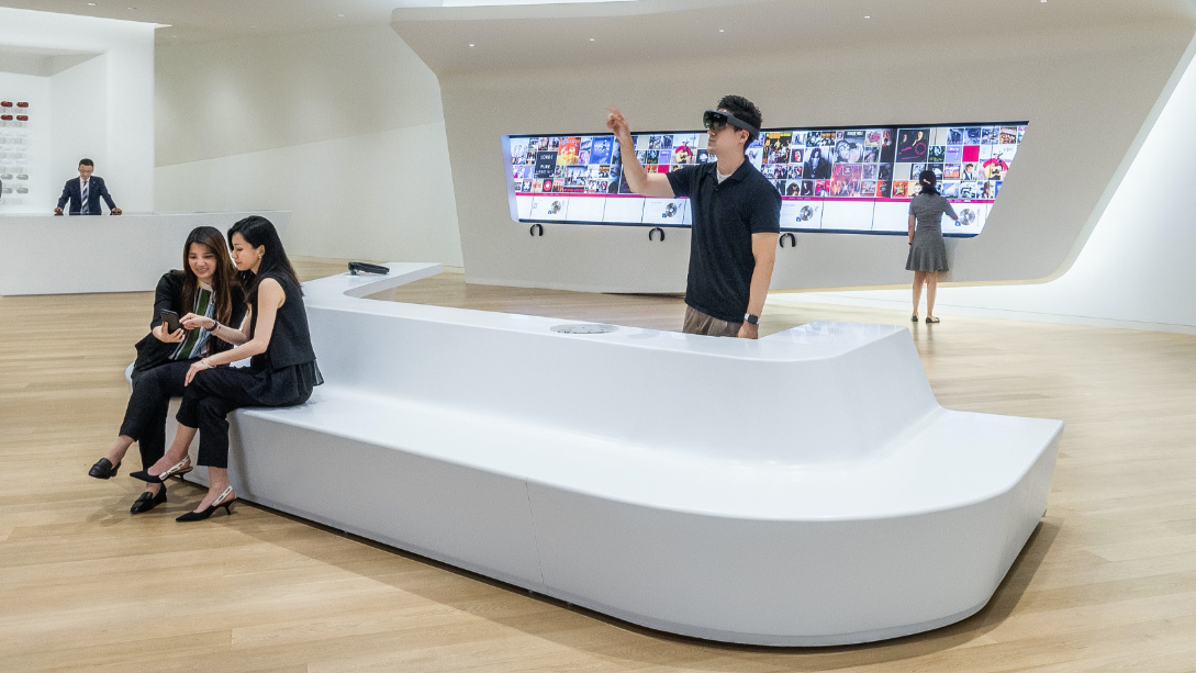 A group of people sitting on a large white table.