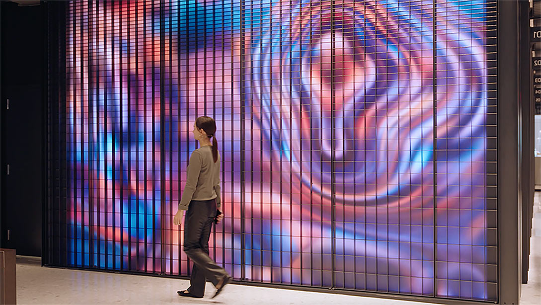 A person standing in front of a large screen.