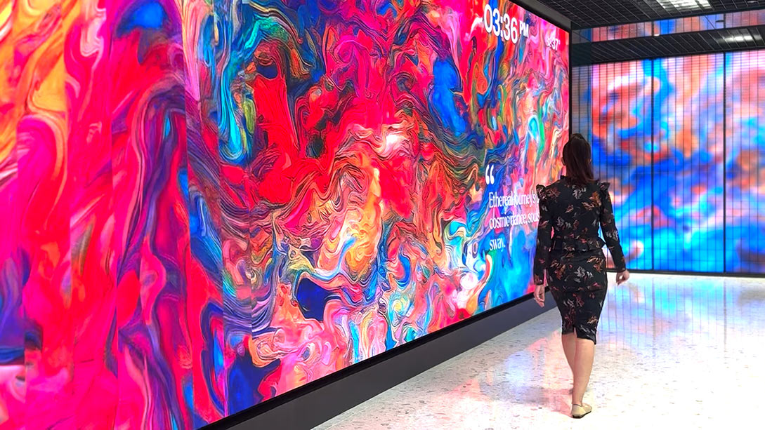 A person walking in front of a large painting.