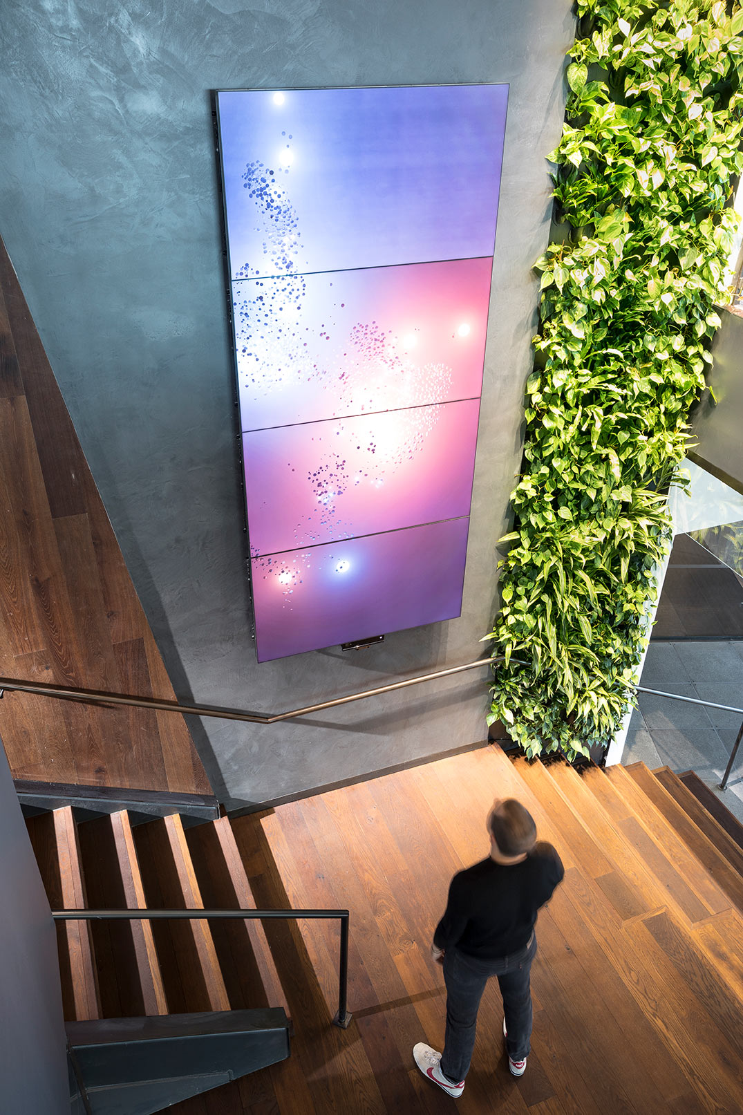 A person standing on a deck looking at a large screen.