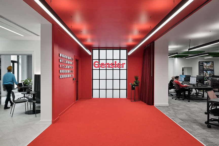 A red carpeted room with a person walking in the front.