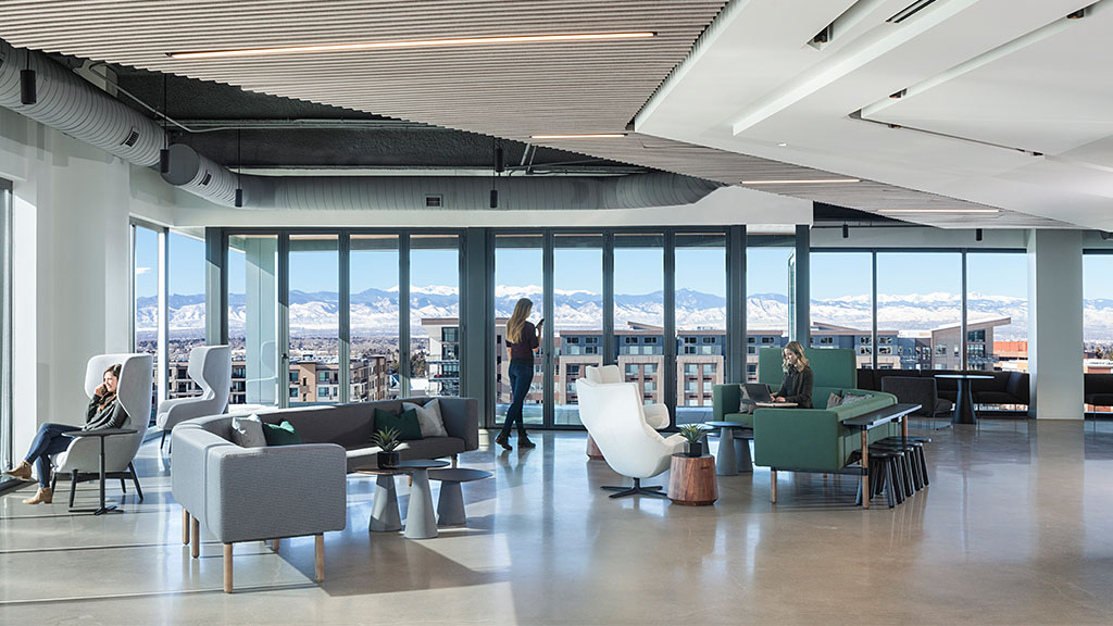 A room with a large window and a group of people sitting in chairs.