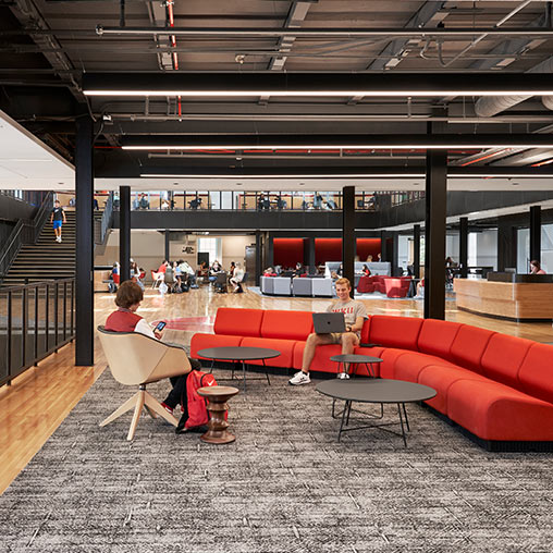 Students on laptops on red couch at Western Kentucky University Helm Library