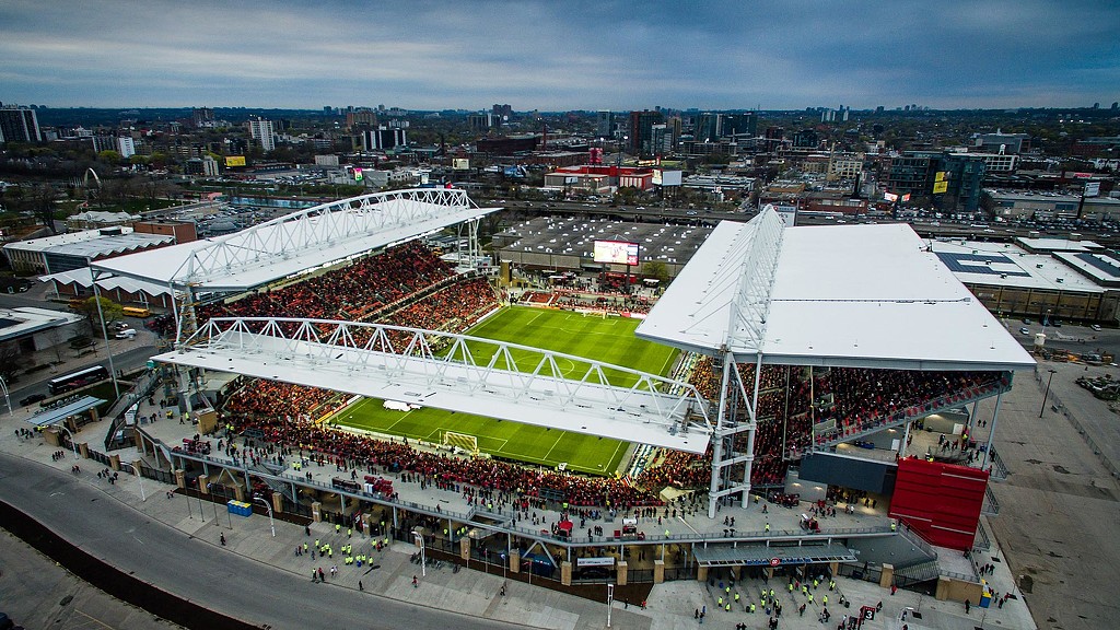 A large stadium with a field and a field in the middle.