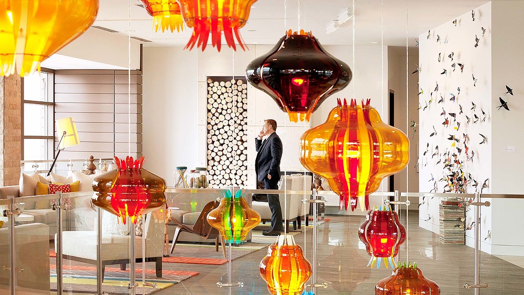 A person standing in a room with many colorful vases.