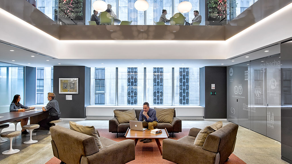 A group of people sitting in a room with a large window.