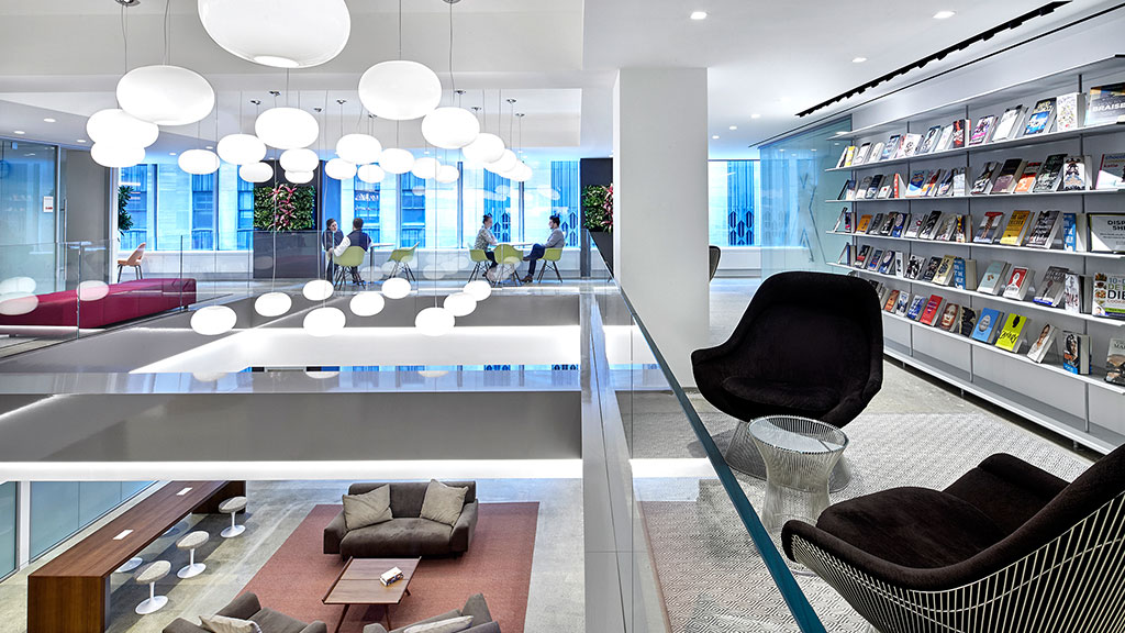 A room with a pool table and chairs and a large glass wall.