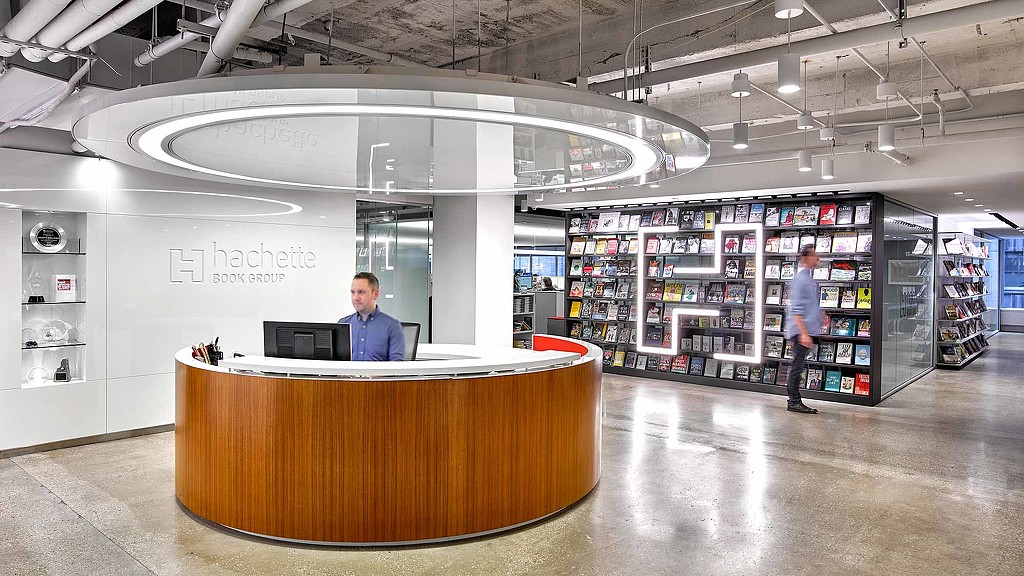 A person standing behind a desk in a store.