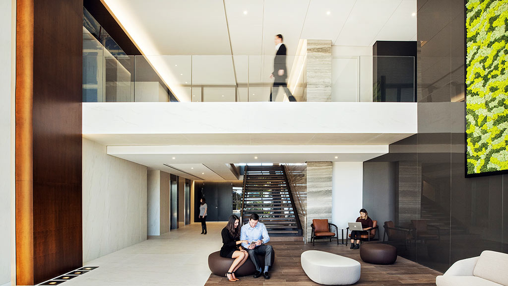 A group of people sitting in a room with a staircase.