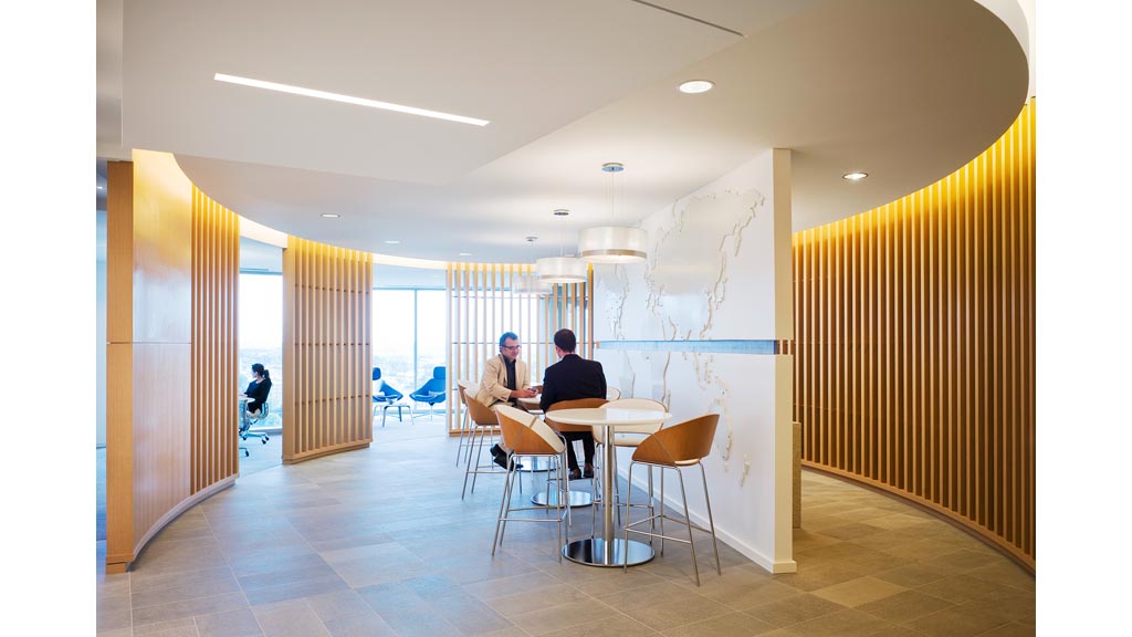 A couple of people sitting at a table in a room with a large window.