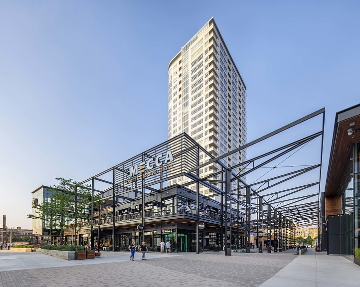 A large metal structure with a walkway and people walking around.