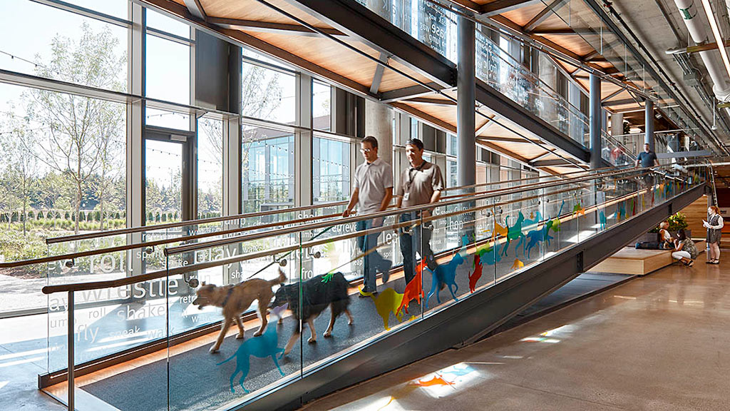 A group of people in a glass room with a large glass wall.